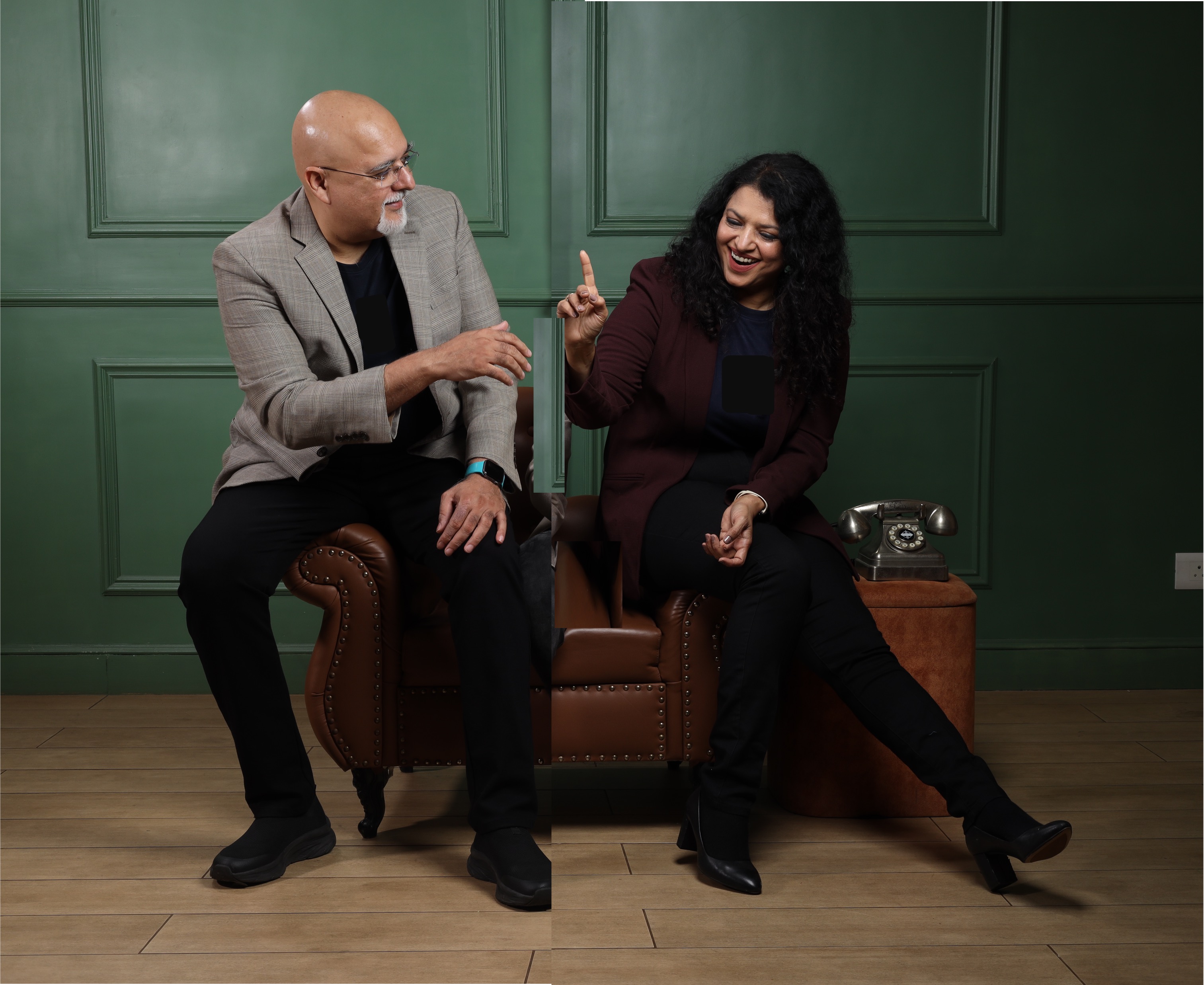 Hemant and Dr. Neha in a candid moment - leather chair, deep green-panelled studio
